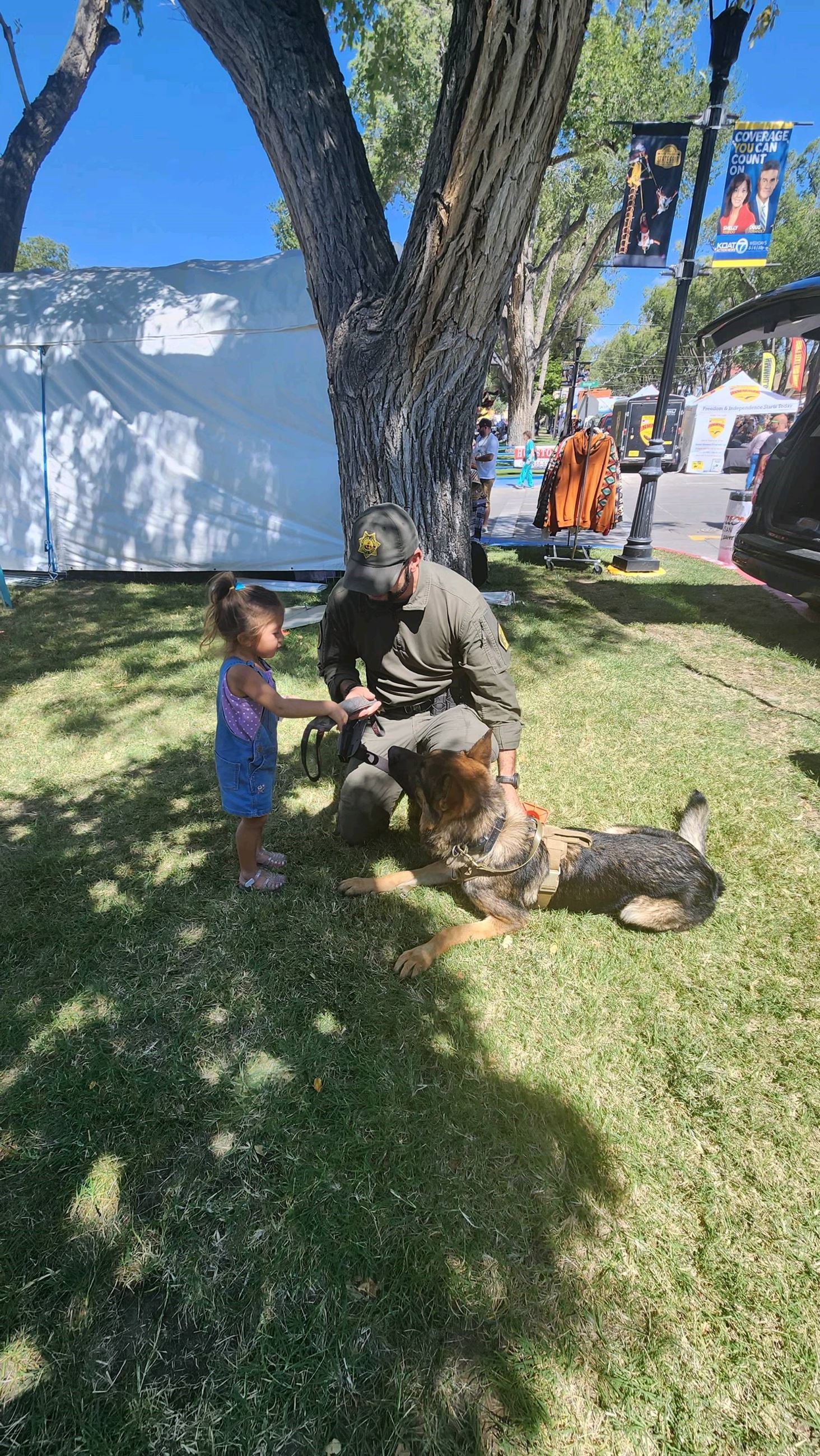 kiddo with the doggo at the Valencia County Sheriff's Office Booth